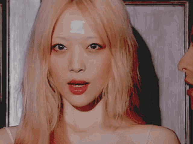 a close up of a woman 's face with blonde hair and red lips