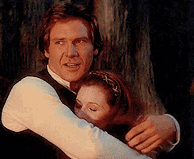 a man is hugging a woman with a headband on her hair