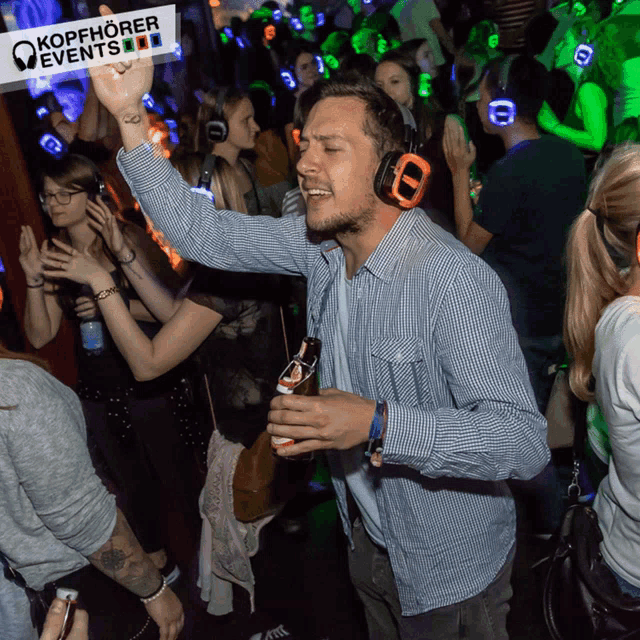 a man wearing headphones is dancing in a crowd at kopfhörer events