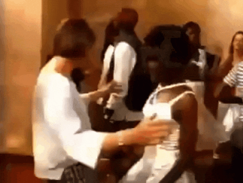 a woman in a white shirt is touching another woman 's arm
