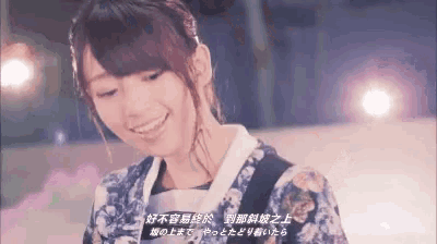 a woman in a kimono is smiling in a video with chinese writing on it