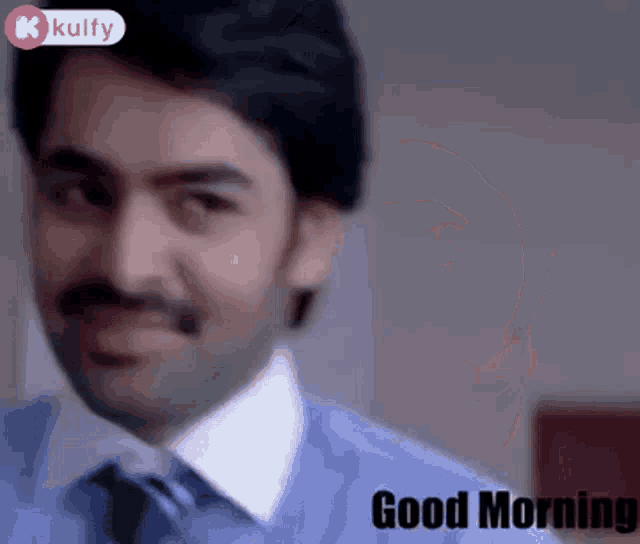 a man with a mustache is smiling and the words good morning are below him