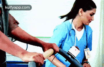 a nurse is helping a patient walk on a treadmill in a hospital room .