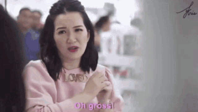 a woman in a pink shirt is making a funny face and says oh gross !