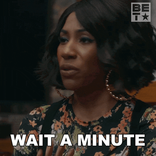a woman says wait a minute in a floral shirt