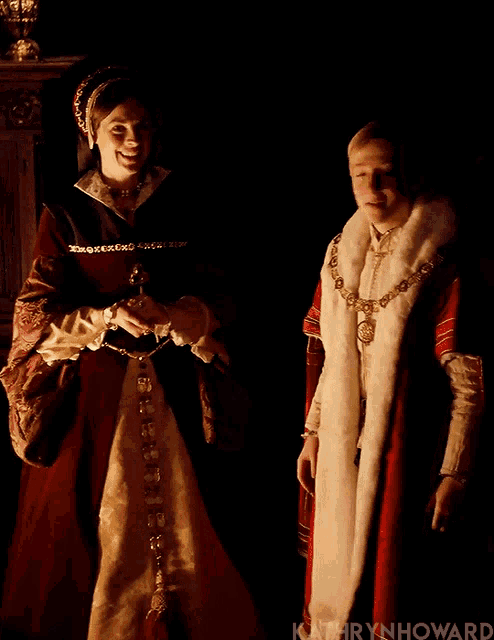 a woman in a red dress stands next to a man in a white coat with the name kathryn howard written on the bottom