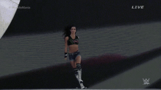 a woman in a wrestling outfit is walking on a stage with the word live on the bottom right