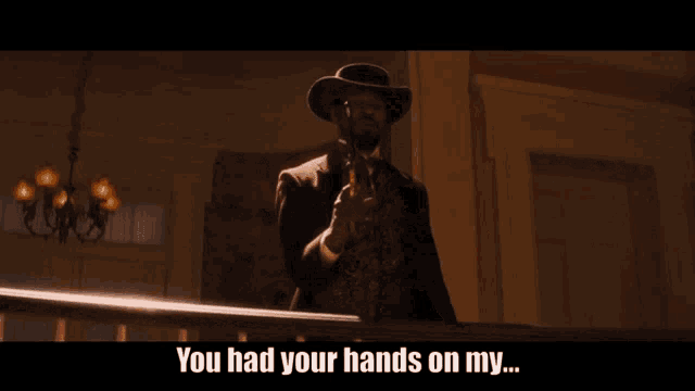 a man in a cowboy hat is pointing a gun with the words you had your hands on my written below him