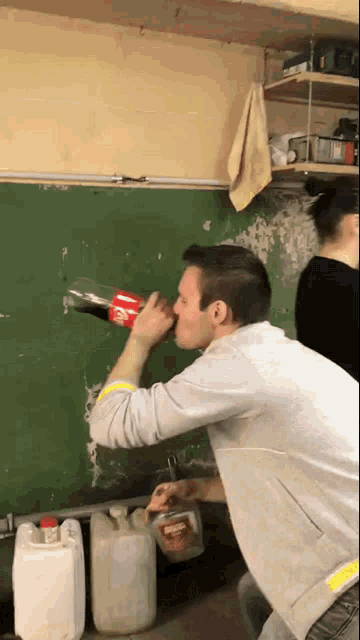 a man drinking a coca cola from a bottle