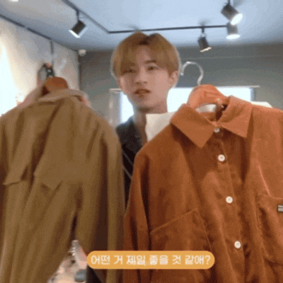 a man is standing in front of a display of clothes with a sticker that says ' oh ? ' on it