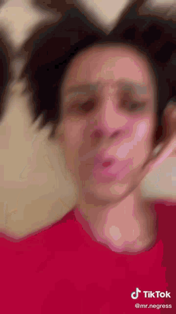 a man in a red shirt is making a funny face with a tiktok watermark