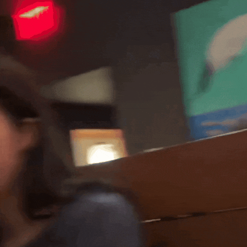 a woman in a blue shirt is looking at something