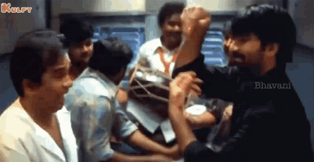 a group of men are fighting each other in a room with a man holding a box .