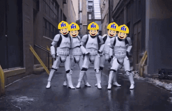 a group of stormtroopers wearing yellow hard hats with the letters rh on them