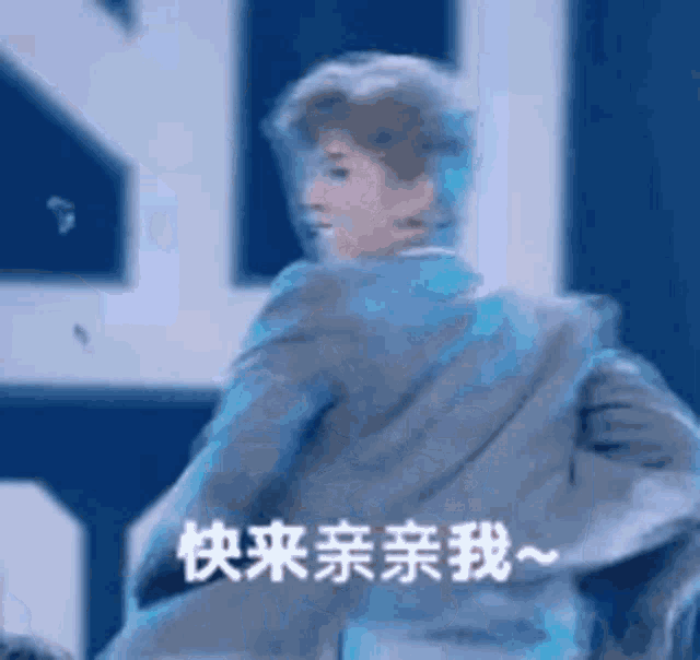 a man in a suit is dancing on a stage in front of a sign in chinese .