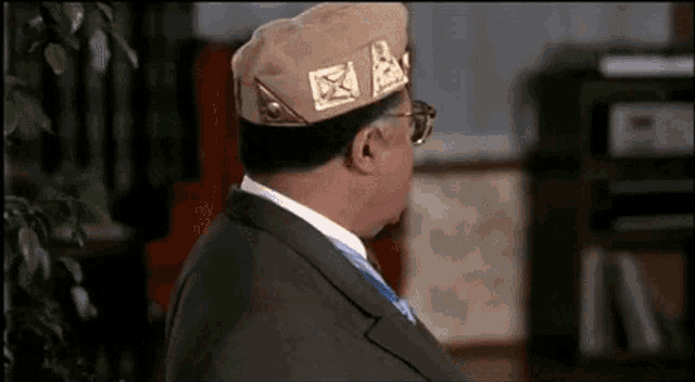 a man in a suit and tie is wearing a military hat .