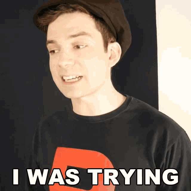 a young man wearing a hat and a shirt that says i was trying on it