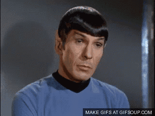 a man in a blue shirt with a black collar is making a sad face .