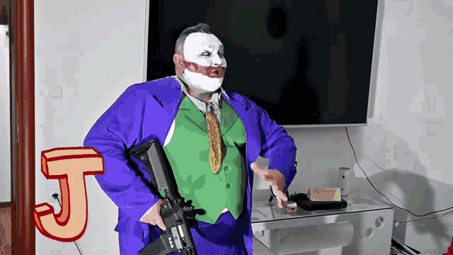 a man in a joker costume is holding a gun and the letter j is behind him