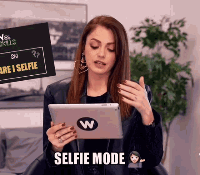 a woman holding a tablet that says selfie mode on the bottom