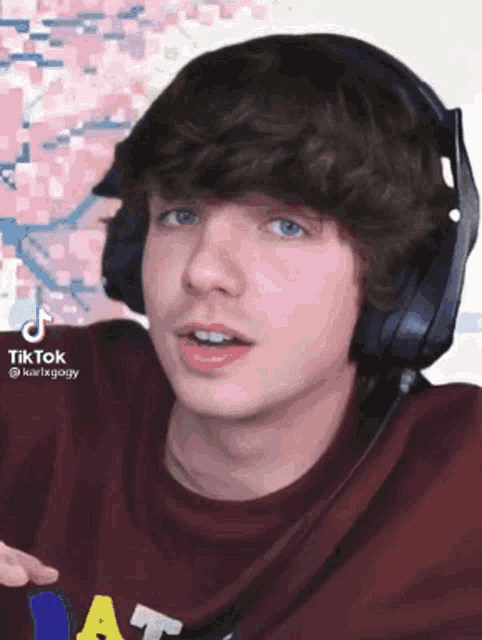 a young man wearing headphones and a red shirt that says ' at ' on it