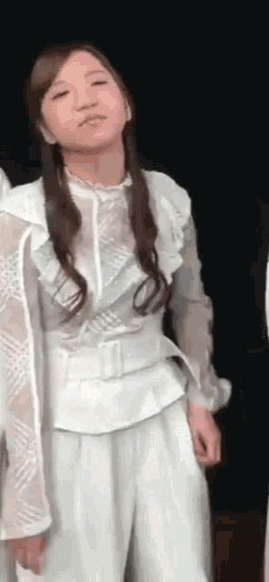 a woman in a white dress is making a funny face .