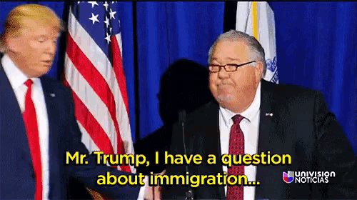 mr. trump has a question about immigration while standing next to another man in front of an american flag
