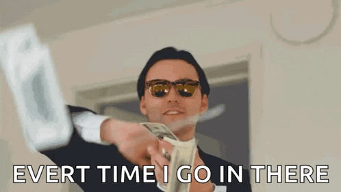 a man in a suit and sunglasses is holding a bunch of money and saying `` ever time i go in there '' .