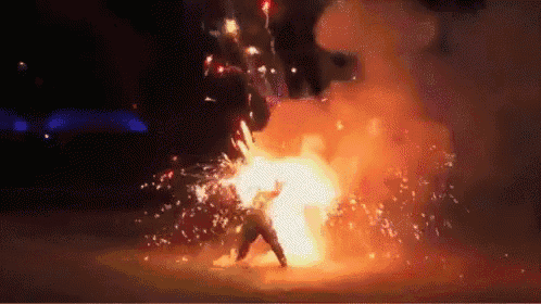a person is standing in front of a large explosion