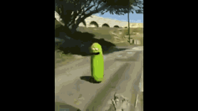 a person in a green costume is walking down a street .
