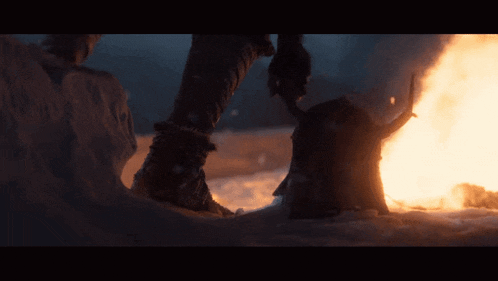 a person standing in front of a fire with a horn on their head