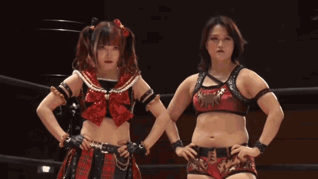 two women are standing next to each other with their hands on their hips and one has a tiger on her top