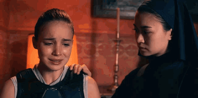 a woman is crying next to a nun