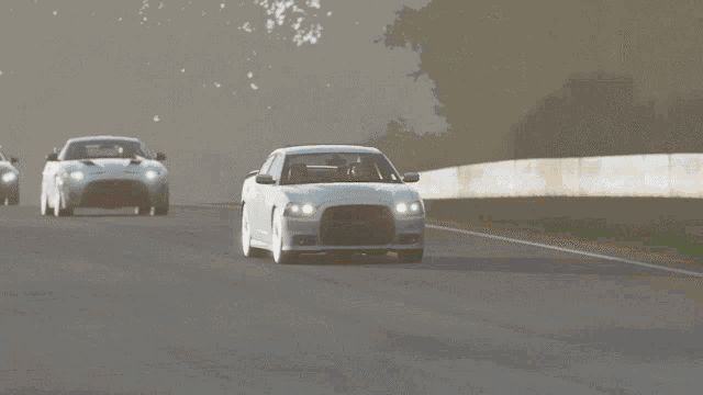 a white dodge charger is driving down a road