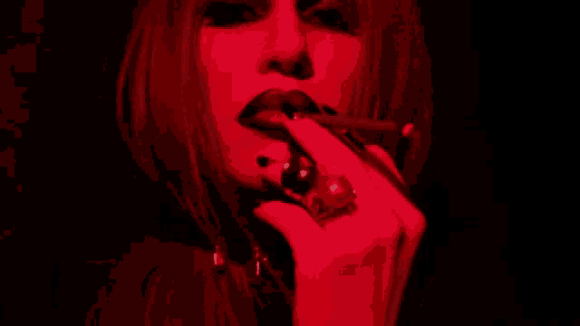 a woman with a ring on her finger is licking her lips
