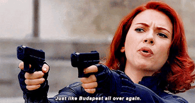 a woman with red hair is holding two guns and says just like budapest all over again .