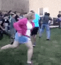a woman in a pink jacket is running in a field