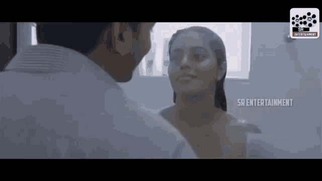 a man and woman are looking at each other in a bathroom with sr entertainment written on the bottom