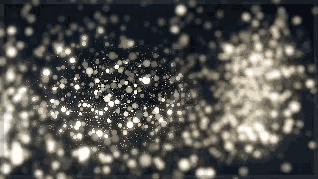 a bunch of white dots are floating in the air on a dark background