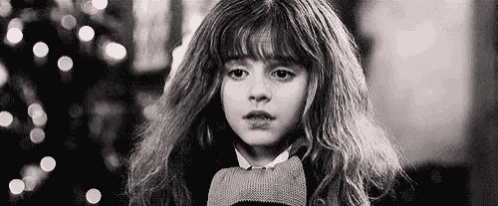 a black and white photo of hermione granger from harry potter wearing a scarf .