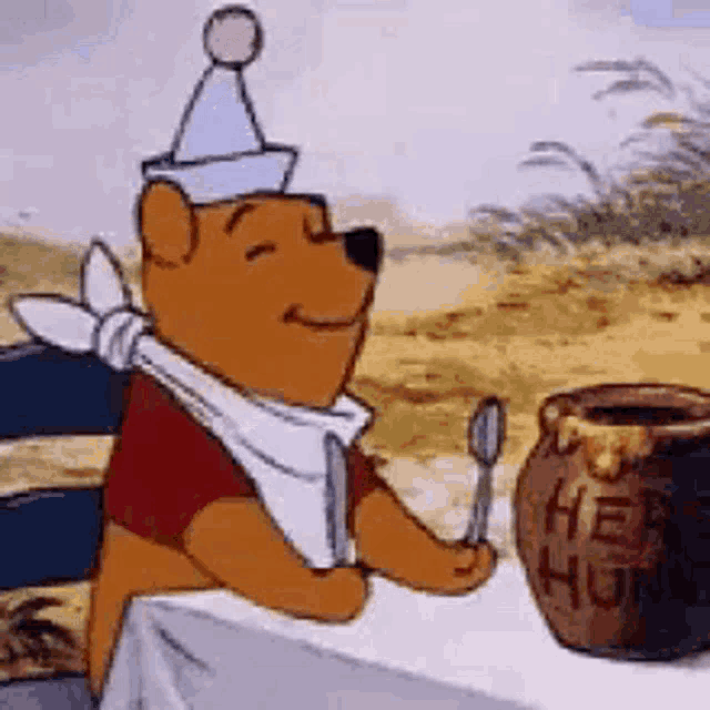 winnie the pooh is sitting at a table holding a spoon and knife .