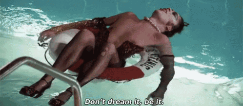 a man is laying on a life preserver in a swimming pool and says do n't dream it , be it .