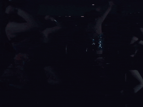 a group of women are dancing in a room with empty chairs