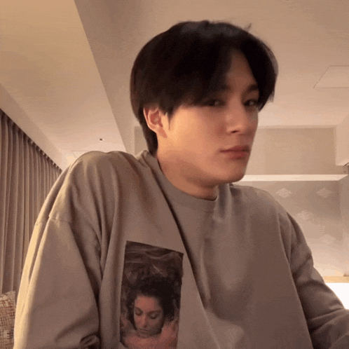 a man wearing a grey shirt has a picture of a woman on it
