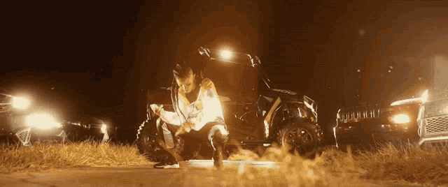 a man is kneeling in front of a jeep that says jeep