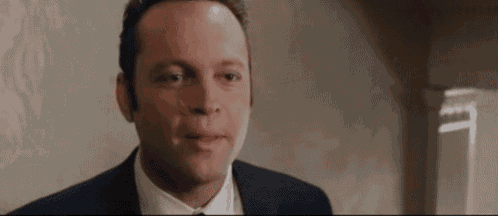 a man in a suit and tie is looking at the camera .
