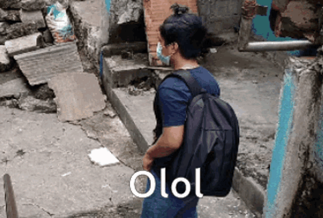 a man wearing a mask and carrying a backpack has the word olol on his back
