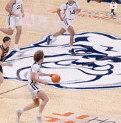 a basketball game is being played on a court with a bear logo on the floor