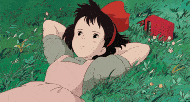 a girl in a pink dress is laying in the grass