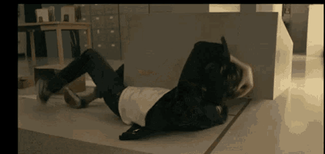 a person is laying on the floor with a backpack on their back .